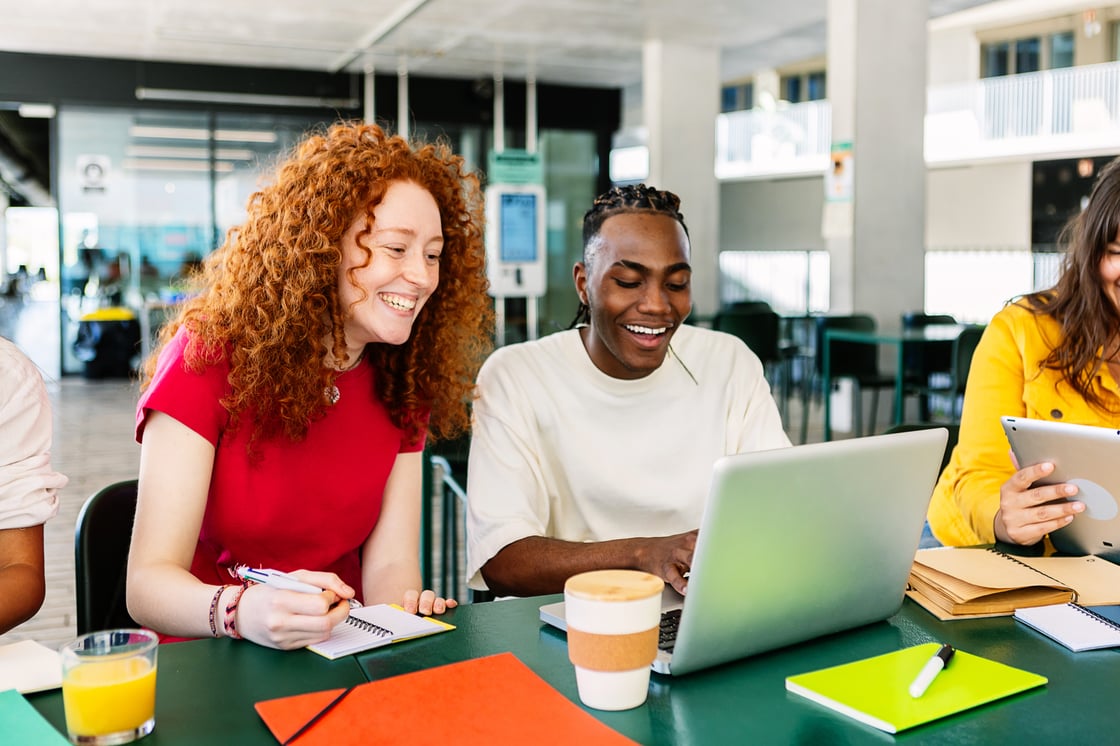 Diverse group of college students studying together at university cafeteria.