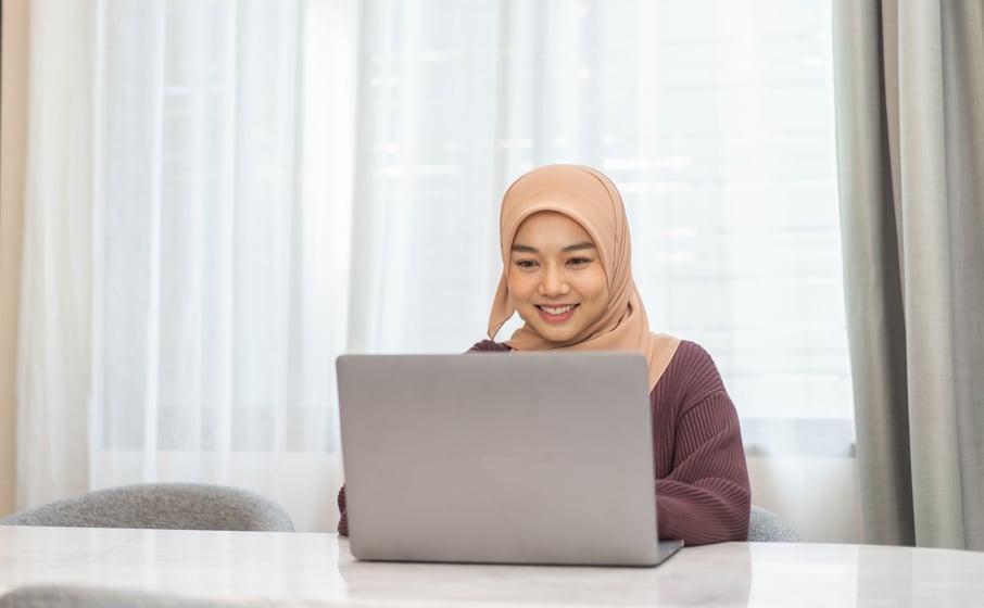Muslim woman in hijab working on laptop